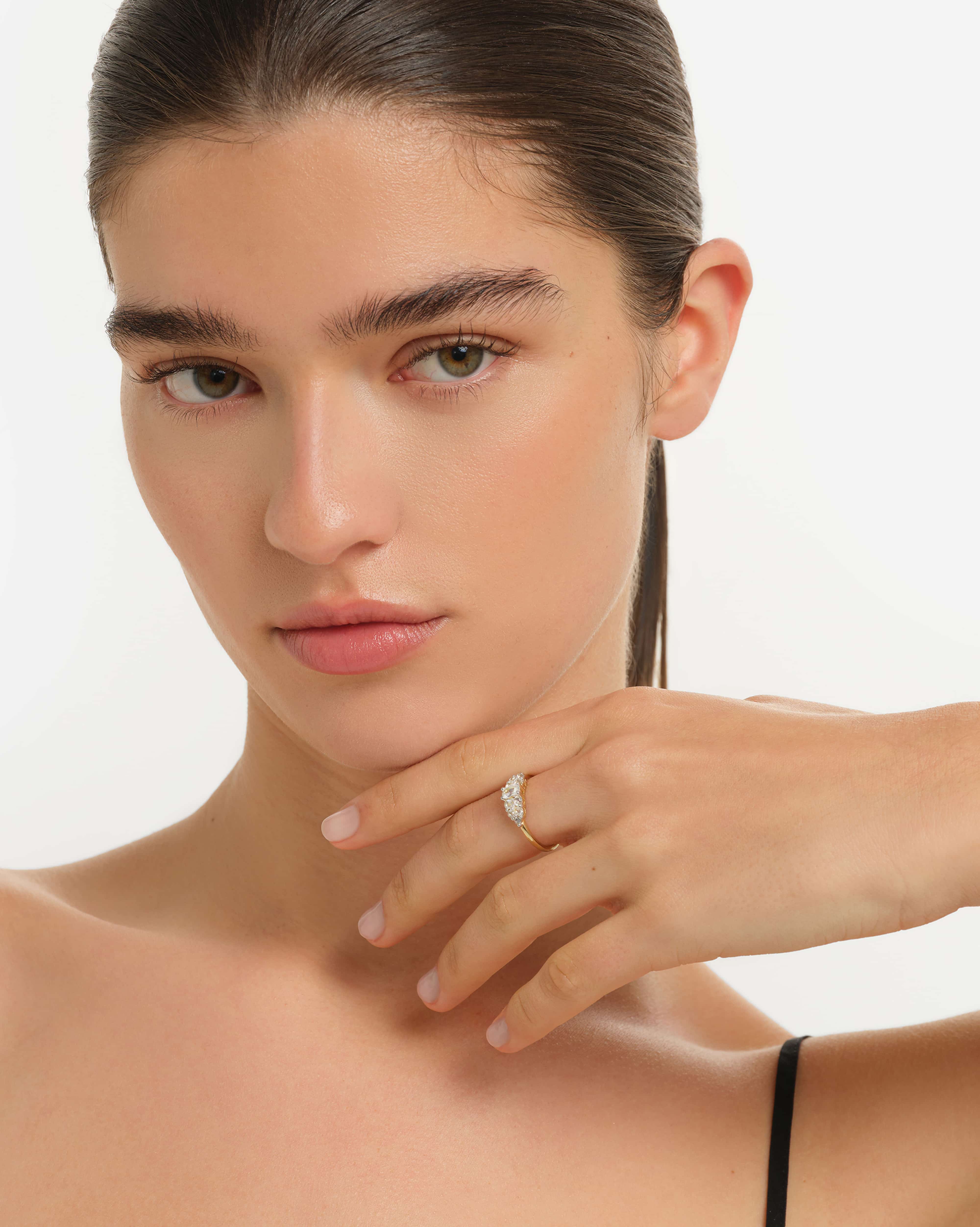 Woman wearing a ring on a plain background